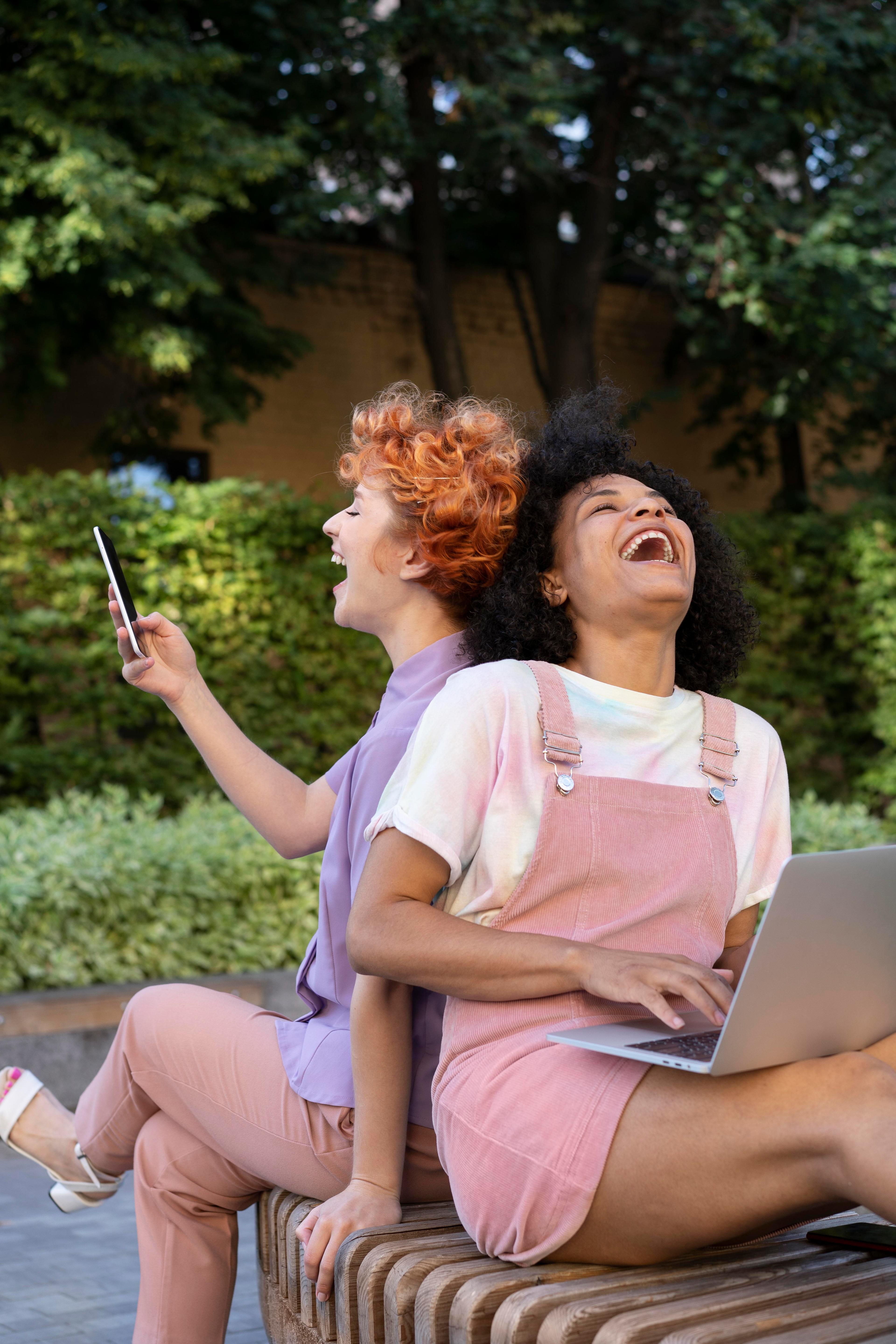Vrouwen lachend achter laptop