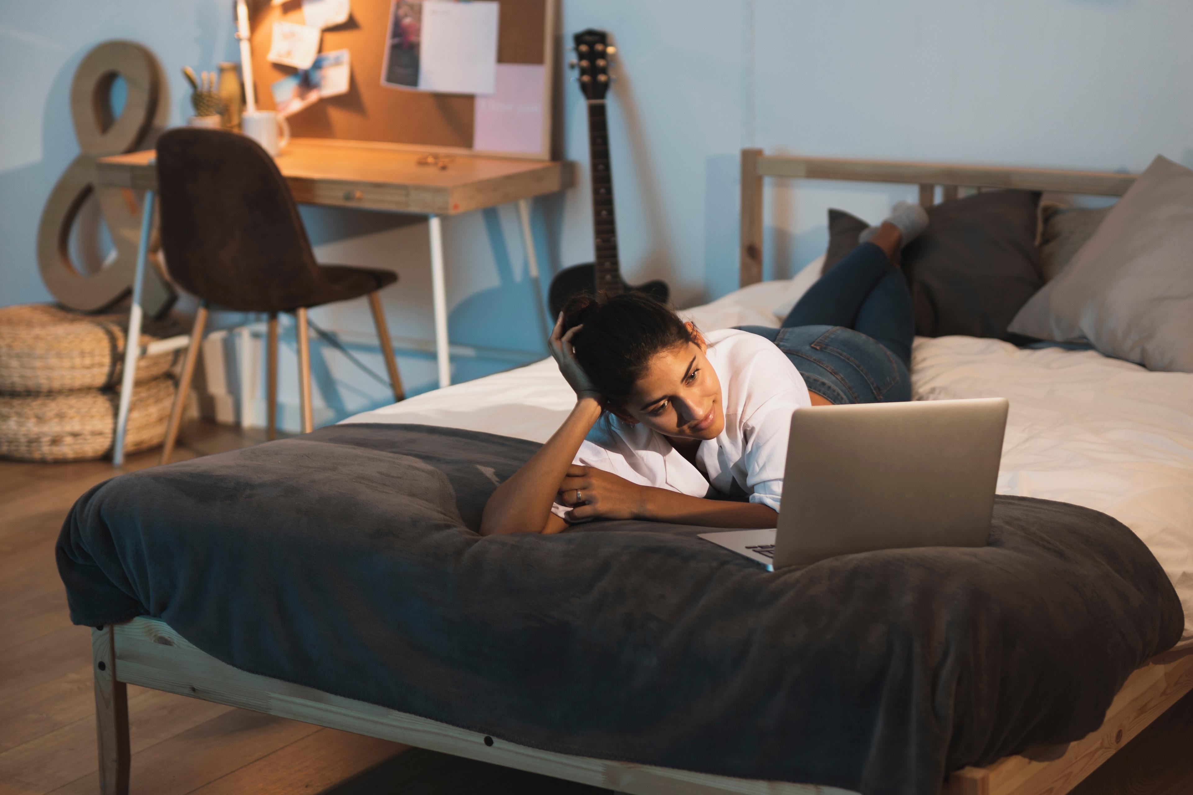 Student met laptop op bed